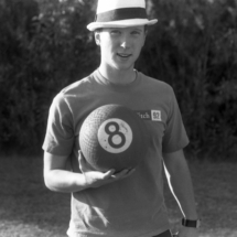 Man holding a kickball and wearing a fedora